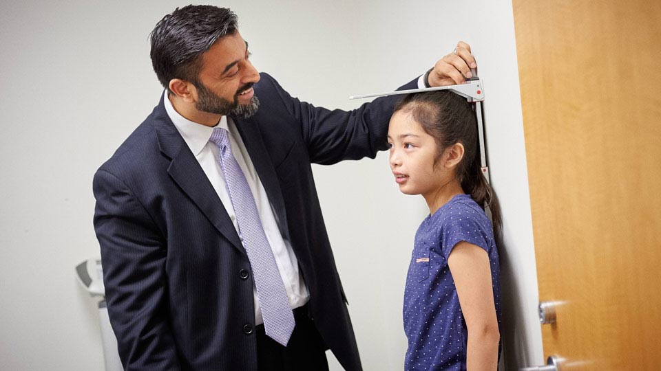 Dr. Rahil Jummani measures a patient’s height at the Child Study Center