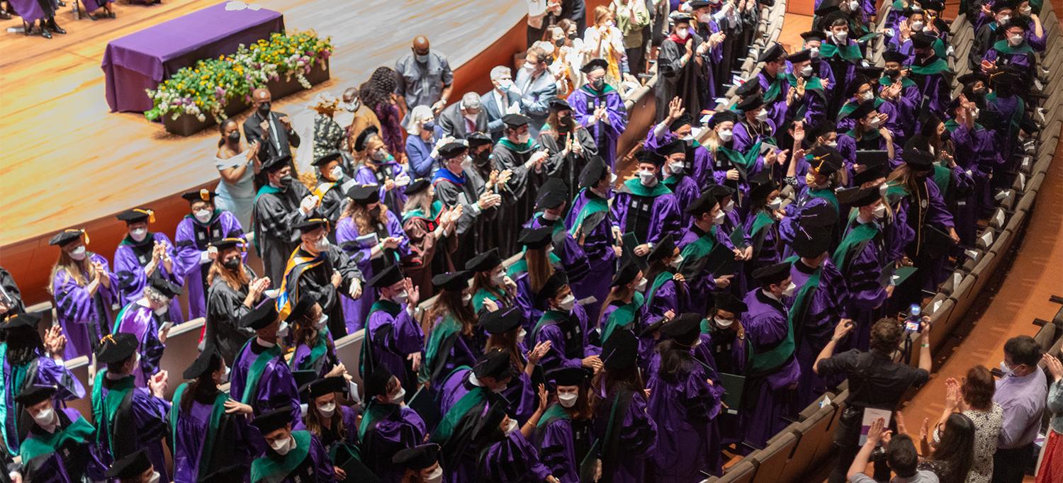 Class of 2022 Wearing Caps and Gowns and Holding Diplomas at Graduation Ceremony