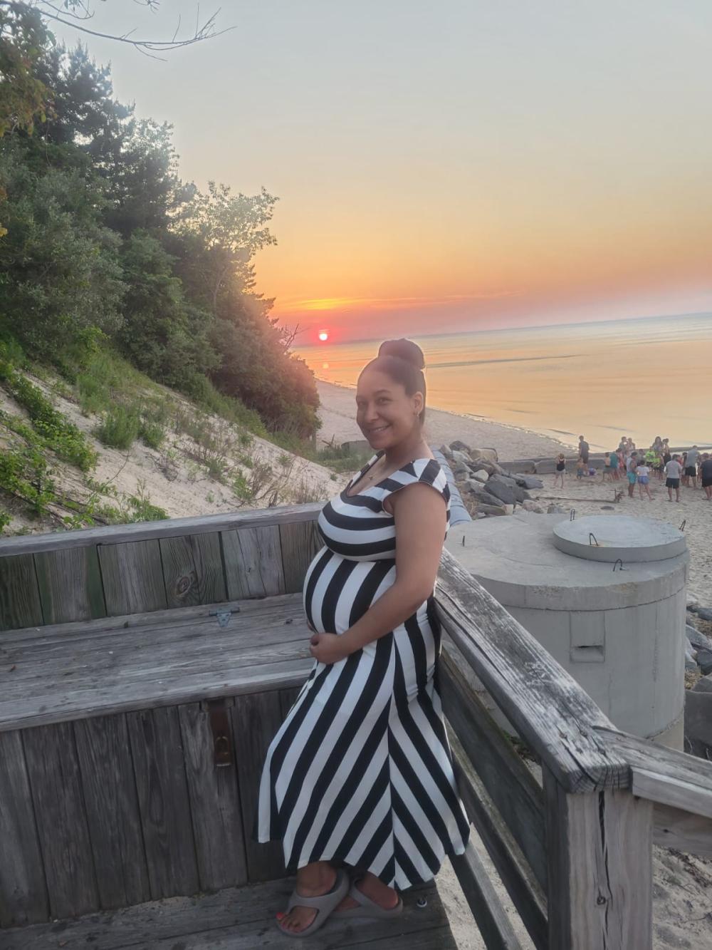 A Visibly Pregnant Yadi Martin Is Photographed on the Beach with the Sun Setting Behind Her