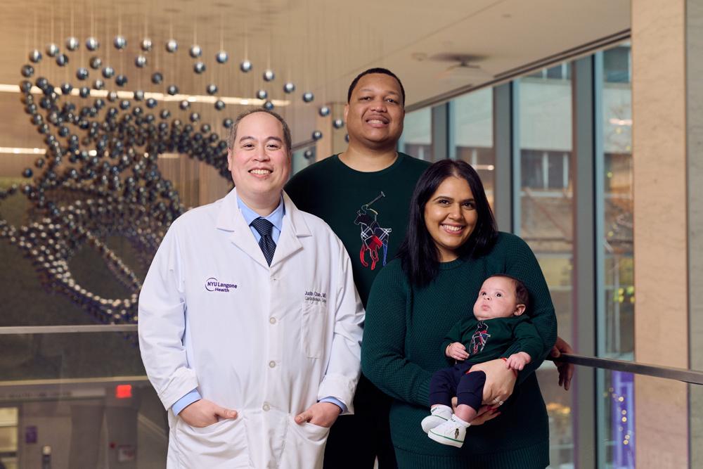 Dr. Justin C. Chan standing and smiling with Alexandra and Michael; Alexandra is holding Jameson.