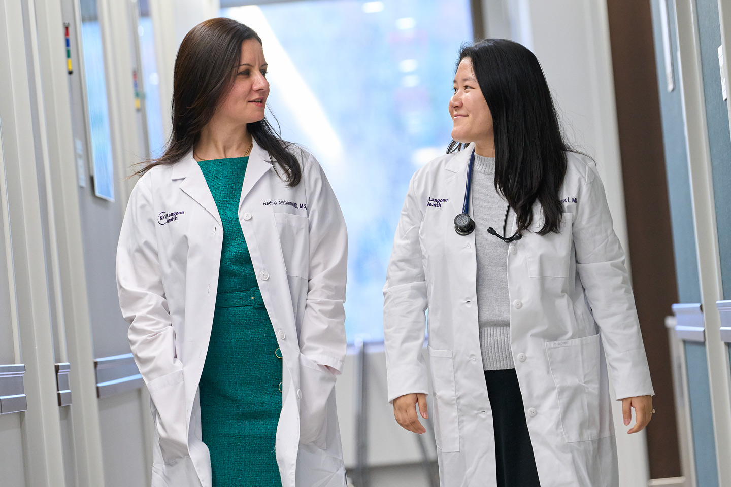 Dr. Hadeel Alkhairw and Dr. Tenzin Desel talk in a hallway of a medical facility.