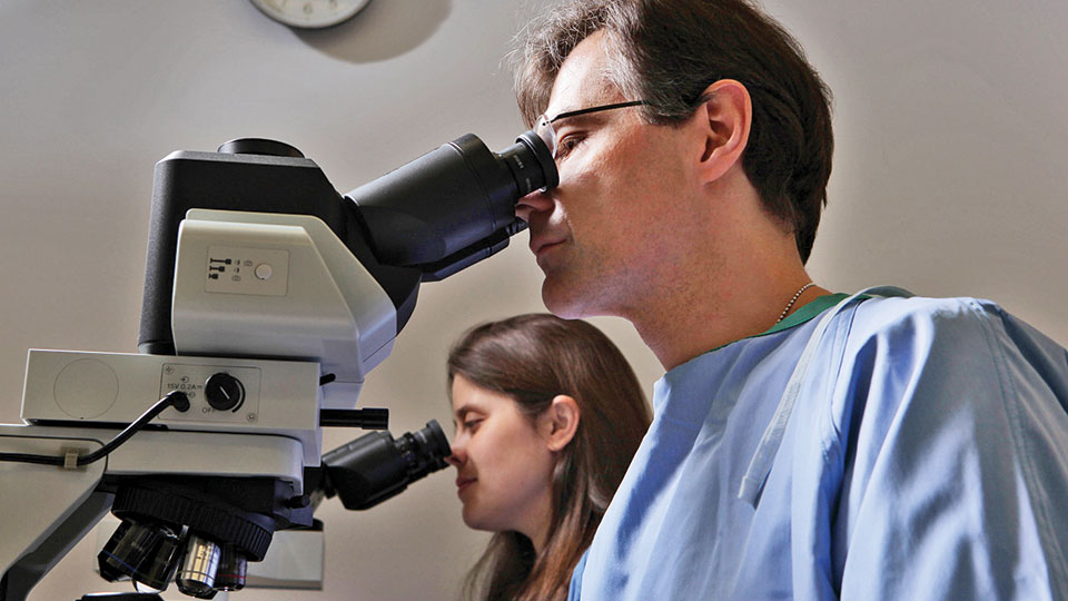 Dr. John Carlucci Uses Microscope