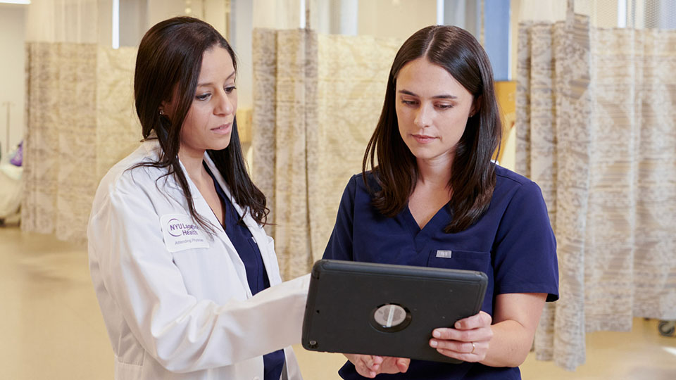Dr. Rita M. Knotts consults with a staff member in a hallway.
