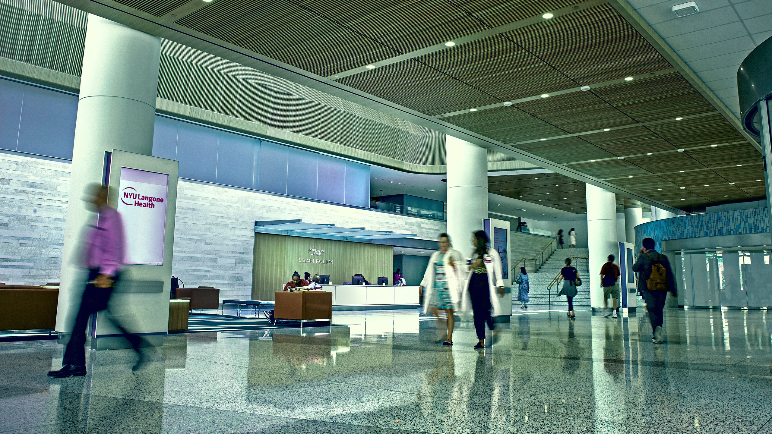 People walking through hospital lobby.