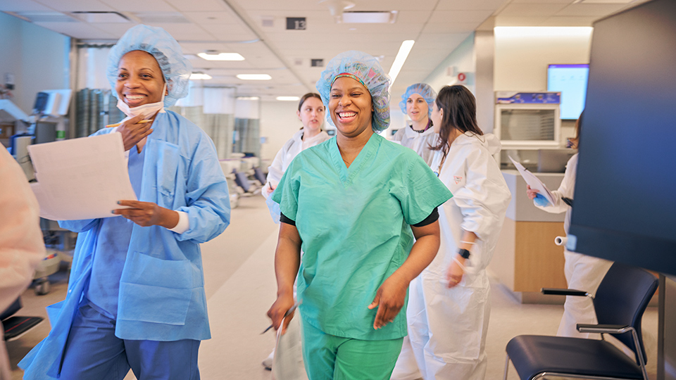 Two Nurses in Scrubs Laughing and Smiling