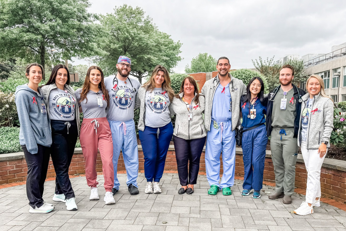 Healthcare providers wearing Race to Rebuild tee shirts stand outside in a group.