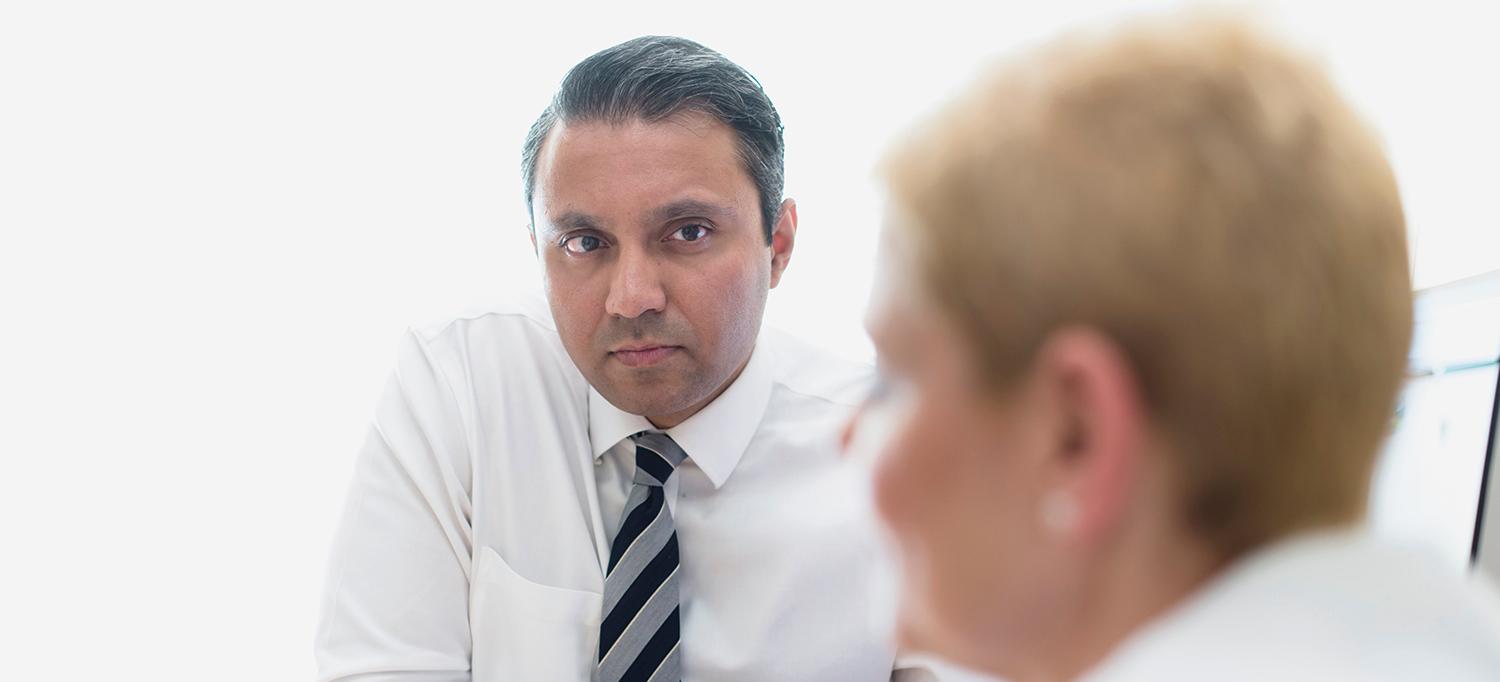Arjun V. Balar, MD, Speaks with a Colleague in an Office