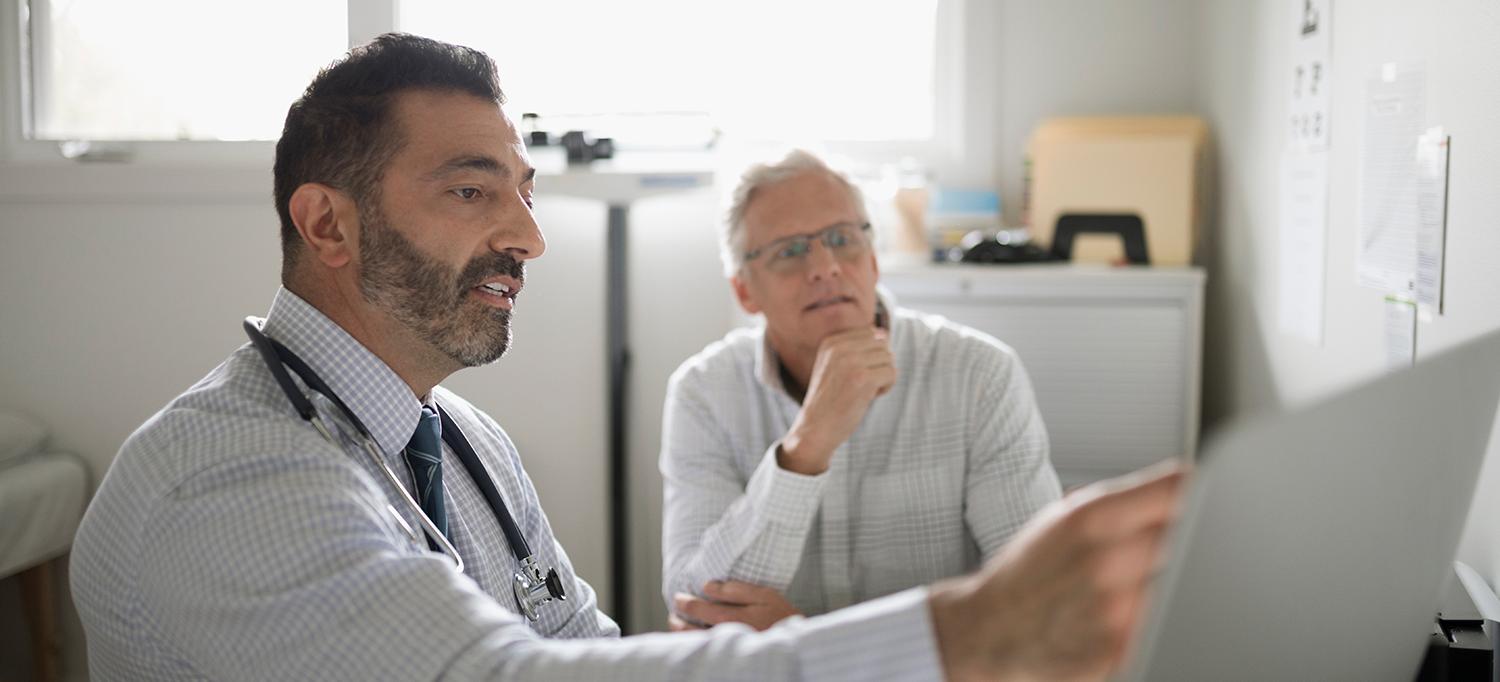 Doctor Reviews Chart with Patient