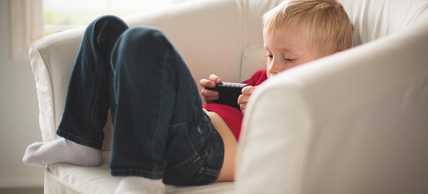 Child Slouches in Chair with Phone