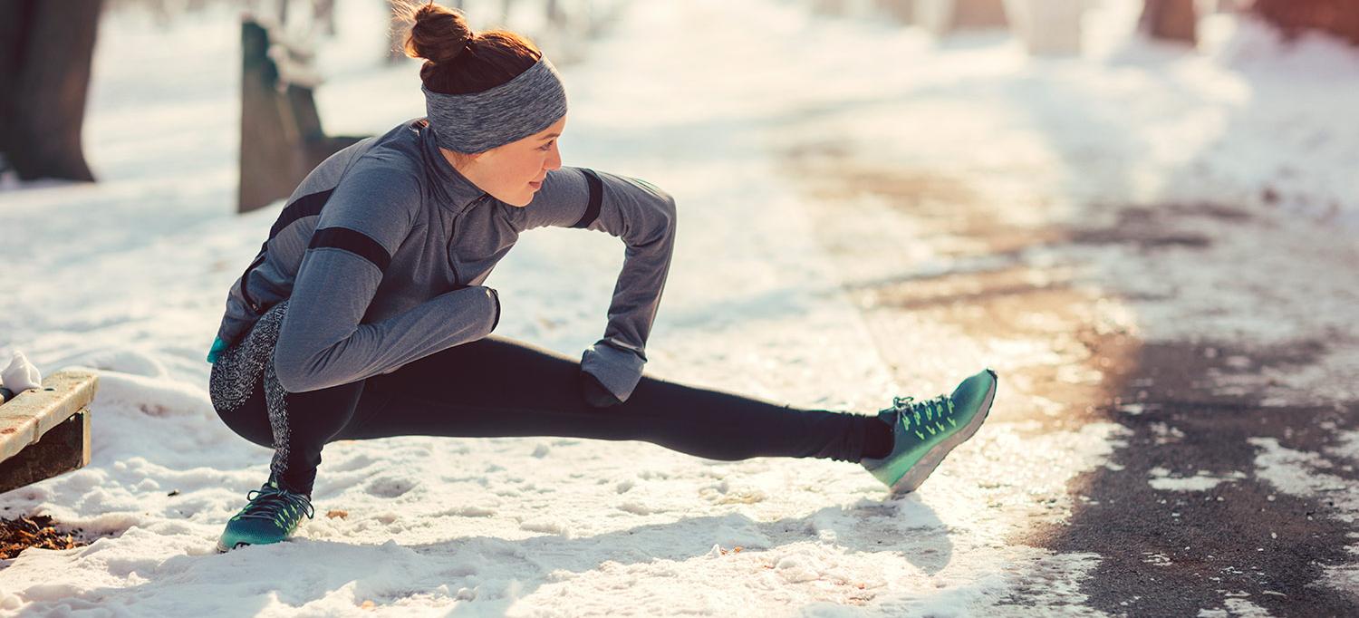 Woman Stretching Outside in Snow