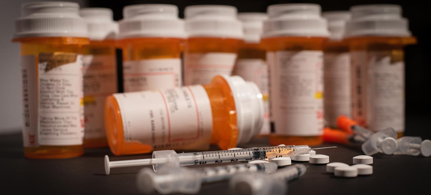 Prescription Bottles, Hypodermic Needles, and Pills