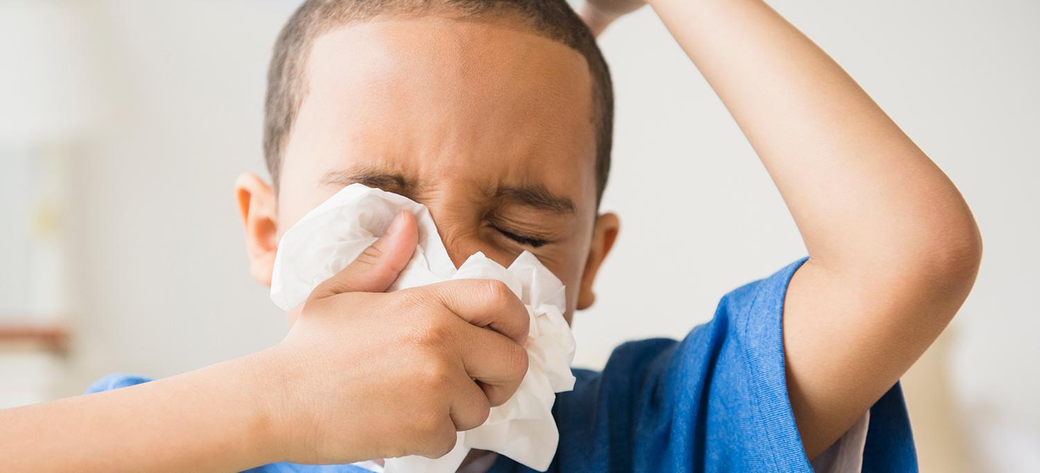 Child Sneezes into Tissue