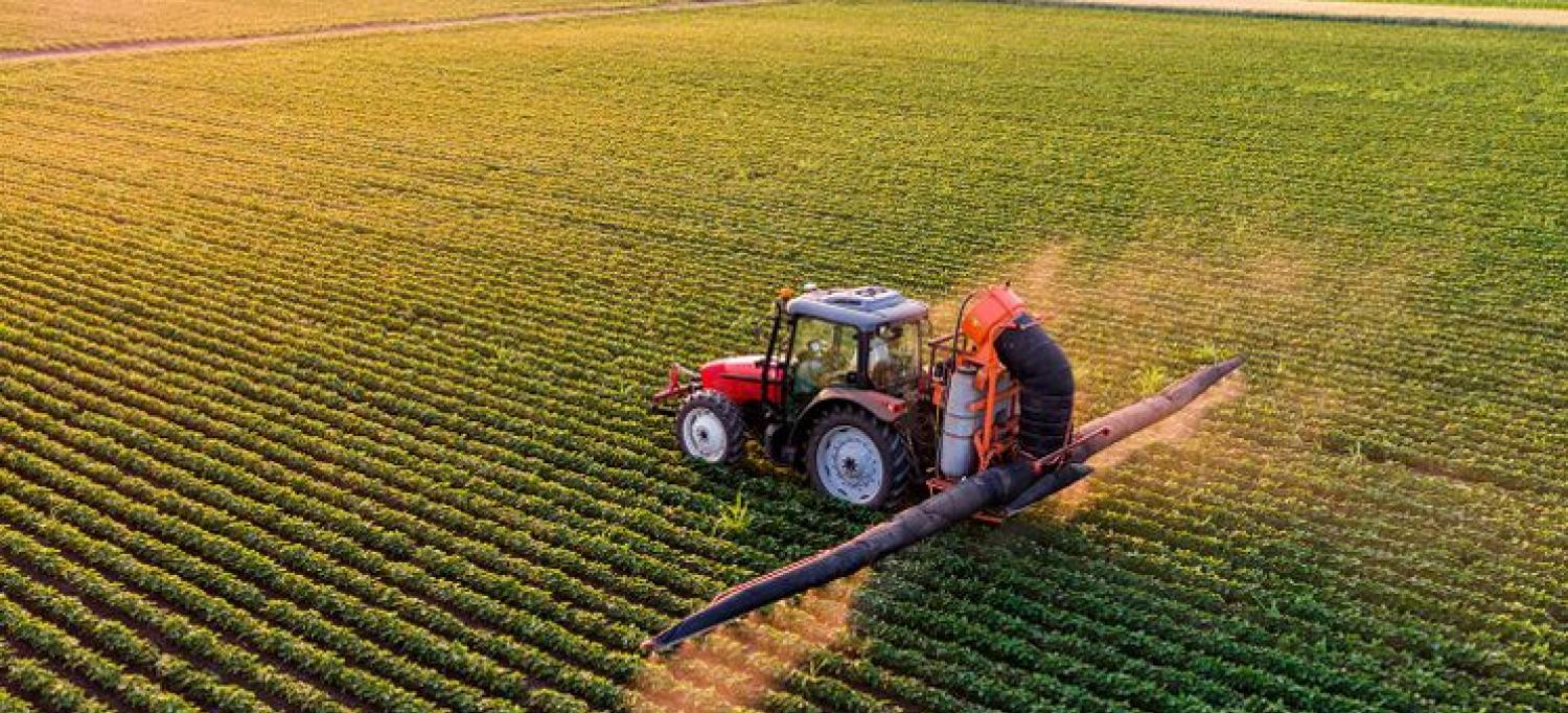 Tractor Sprays Pesticides on Crops