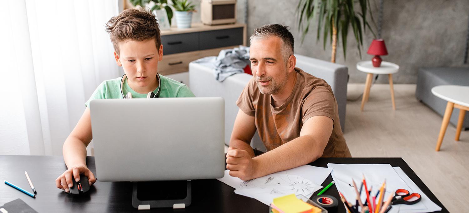 Father Helps Son with Schoolwork on Laptop Computer