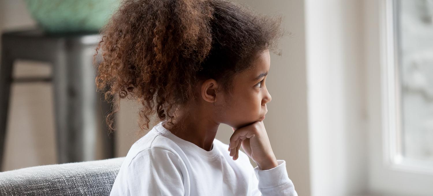 Child Sitting on Couch and Looking Out Window