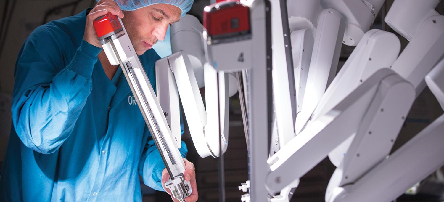 Doctor Positions a Robotic Surgery Machine in Preparation for Surgery