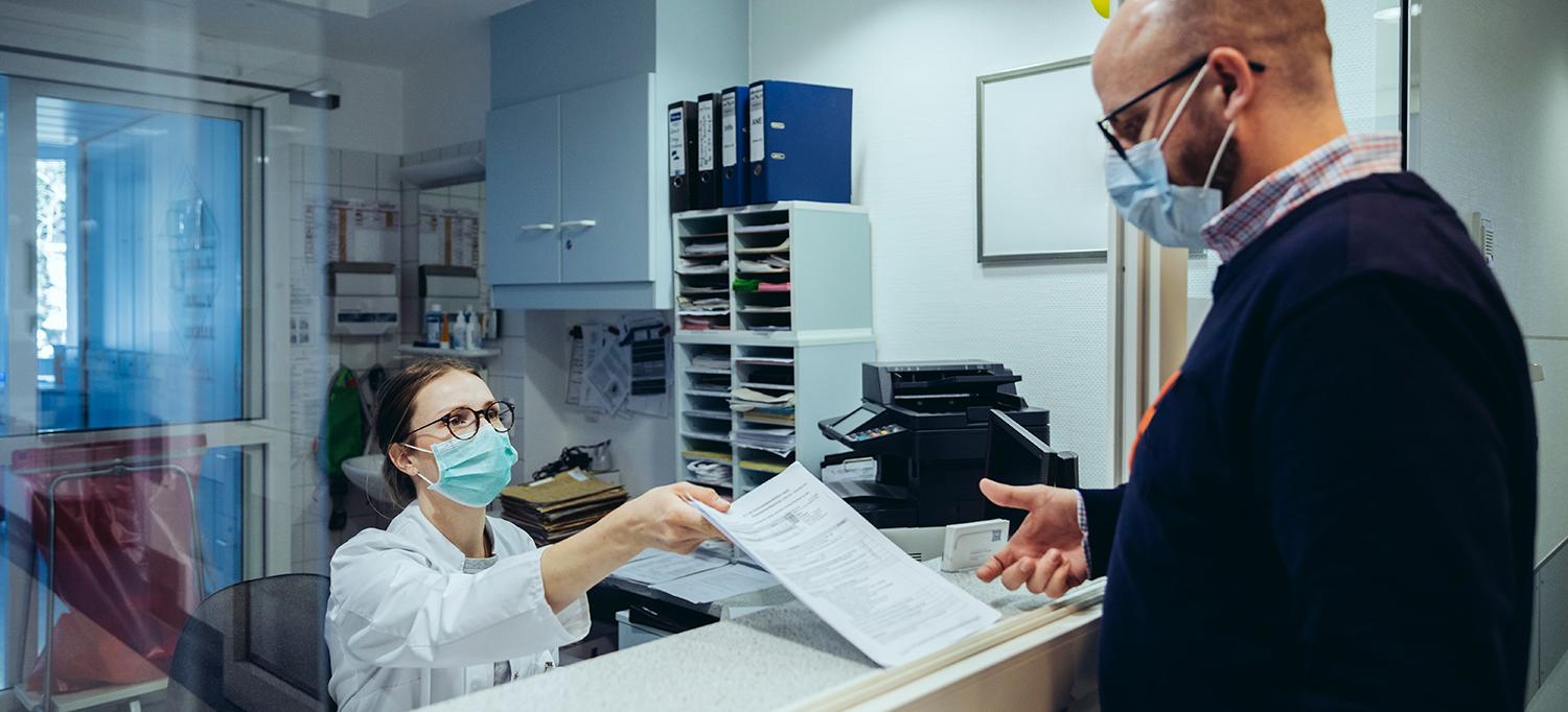 Healthcare Worker at Desk Hands Patient Form