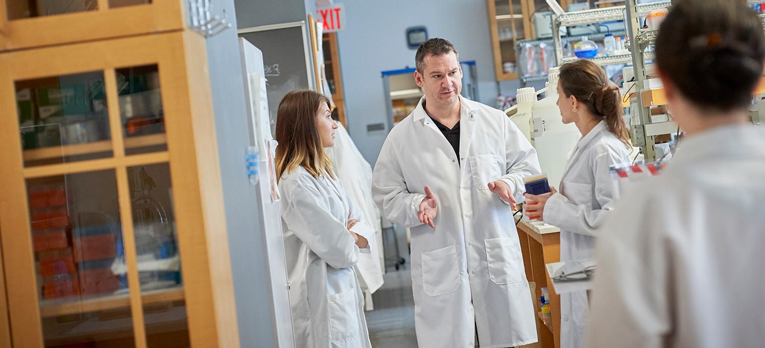 Dr. Robert C. Froemke Talking with Colleagues in Lab