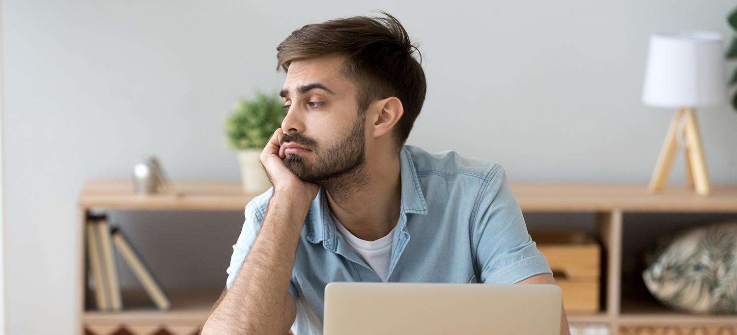 Man Sitting at Desk, Staring Off to the Side