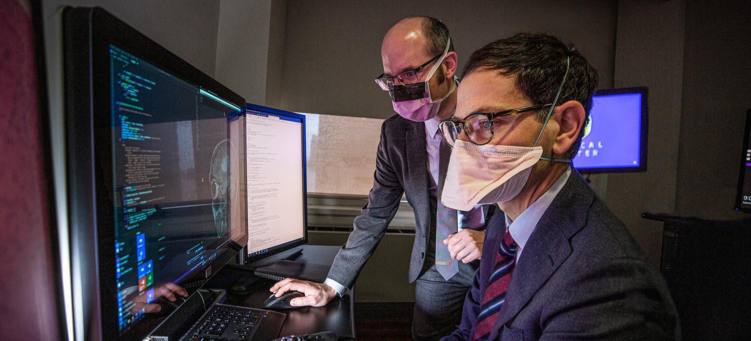 Dr. Eric K. Oermann and Dr. Daniel A. Orringer Wearing Face Masks and Reviewing Computer Analyses