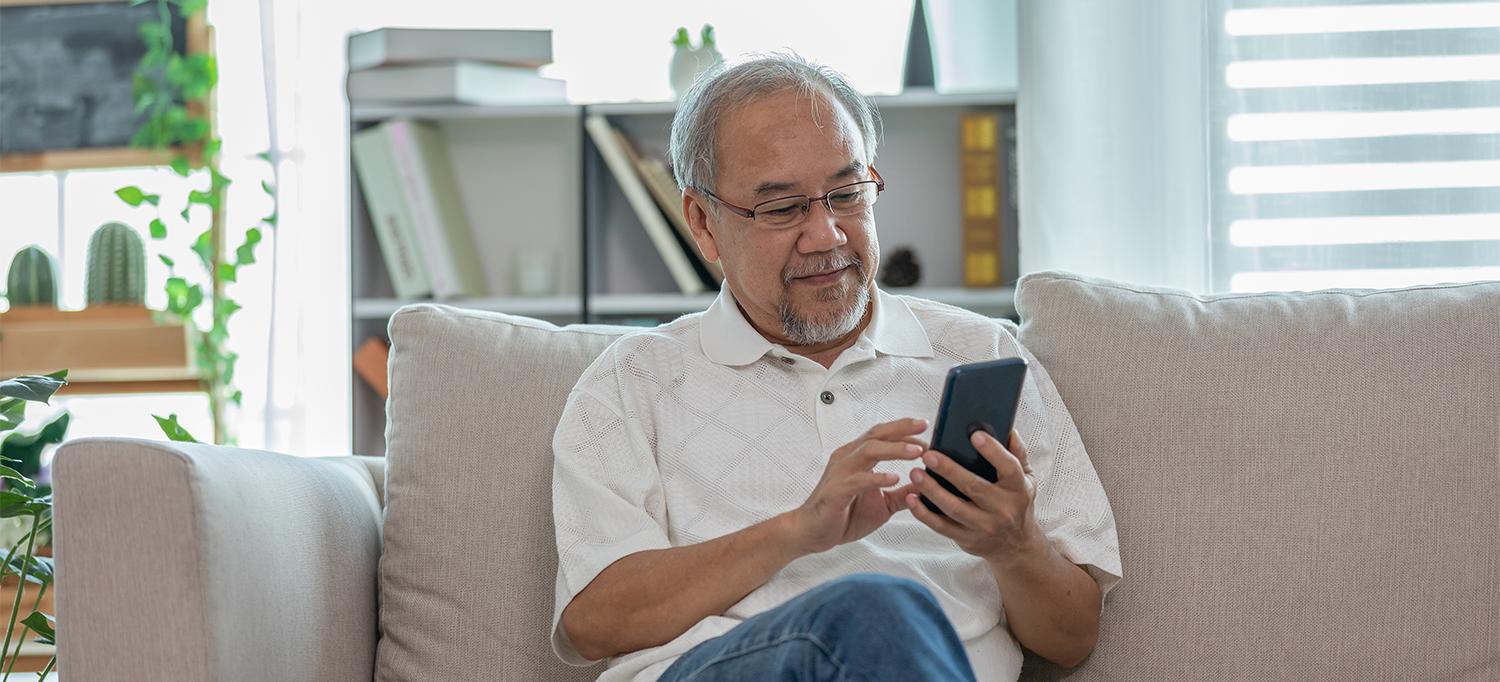 Man Sitting on Couch Using Smartphone