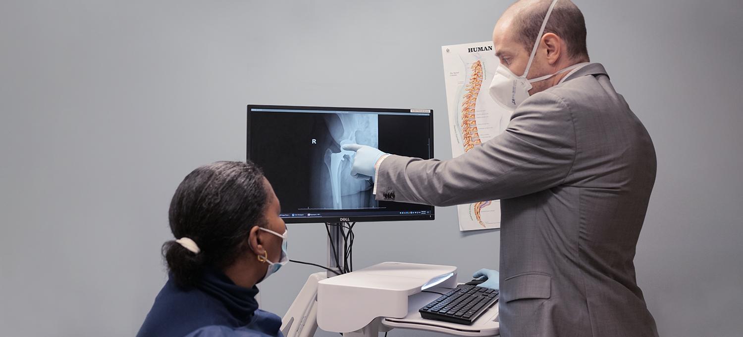 Doctor Reviews Hip X-ray With Patient