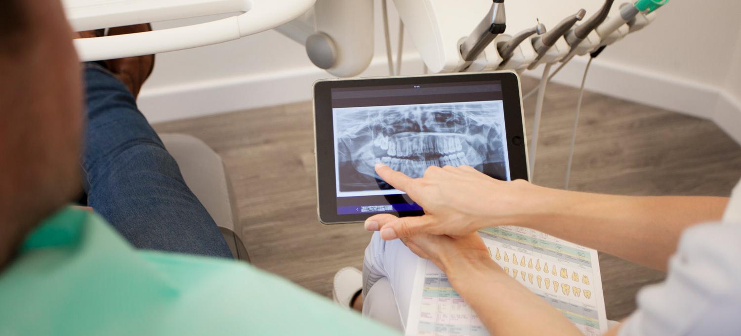 Dentist Reviews Dental X-Rays with Patient