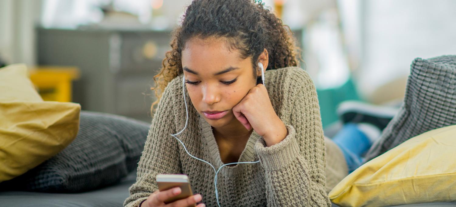 Teenager Wearing Headphones Looking at Phone