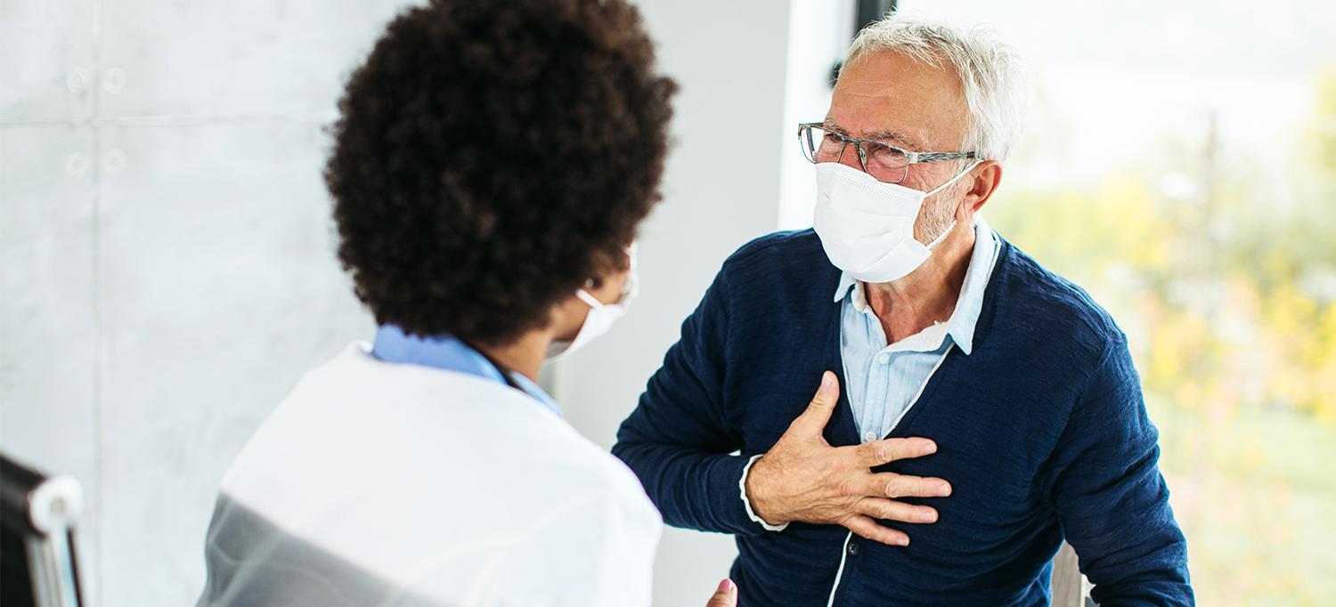 Older Person Wearing Face Mask Speaking with Healthcare Provider