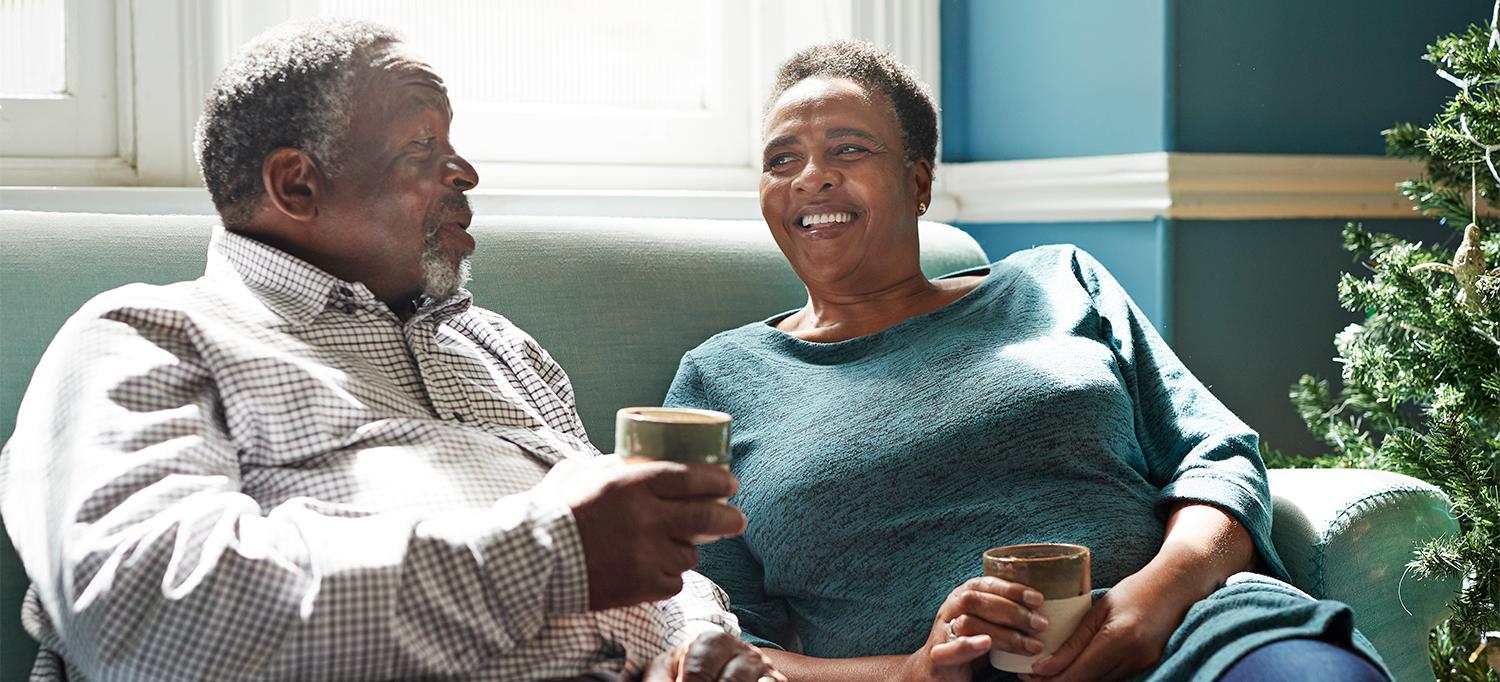 Couple Talking While Sitting on Couch Having Coffee