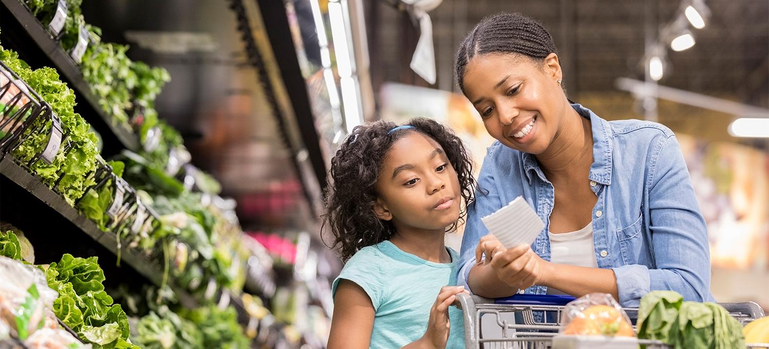 Adult and Child Check Grocery List in Produce Section