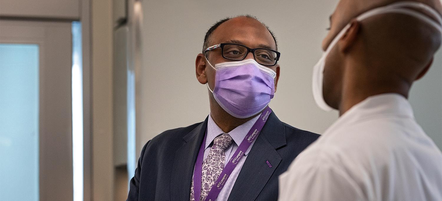 Dr. Paresh C. Shah Speaking with Colleague, Both Wearing Face Masks