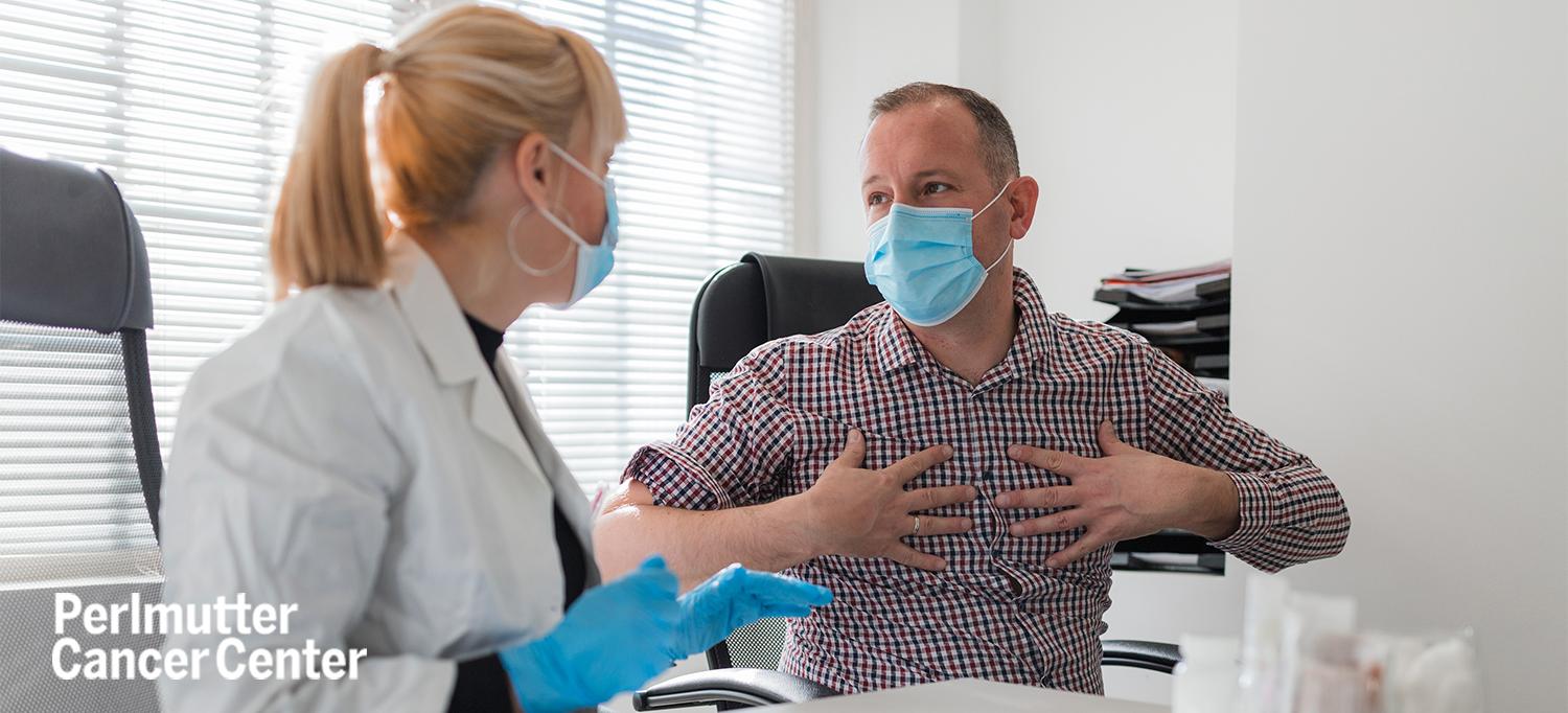 Patient Touching Chest and Speaking with Doctor