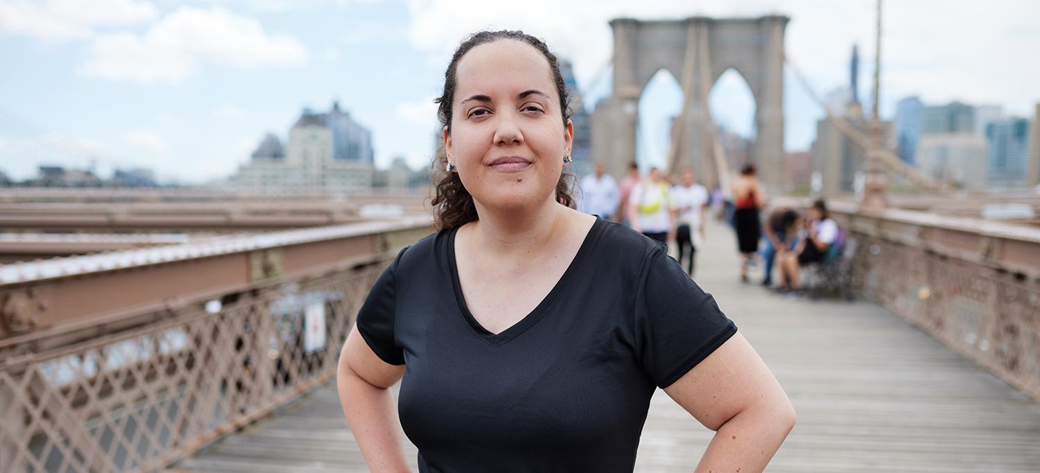 Rachel Freedman Stands with Hands on Hips on Brooklyn Bridge Pedestrian Path