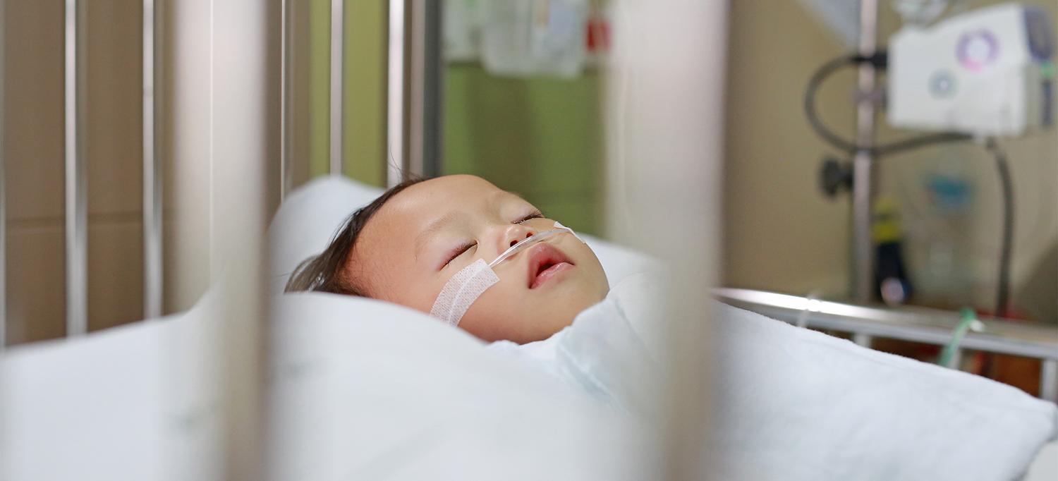 Child Lying in Hospital Bed Receiving Oxygen Through Nasal Cannula