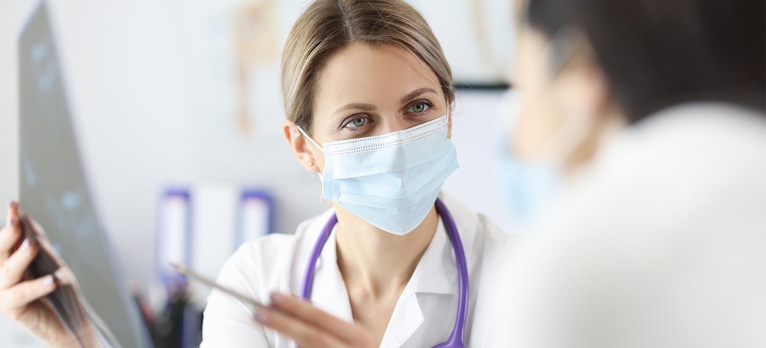 Healthcare Provider Reviewing Imaging Results with Patient, Both Wearing Masks