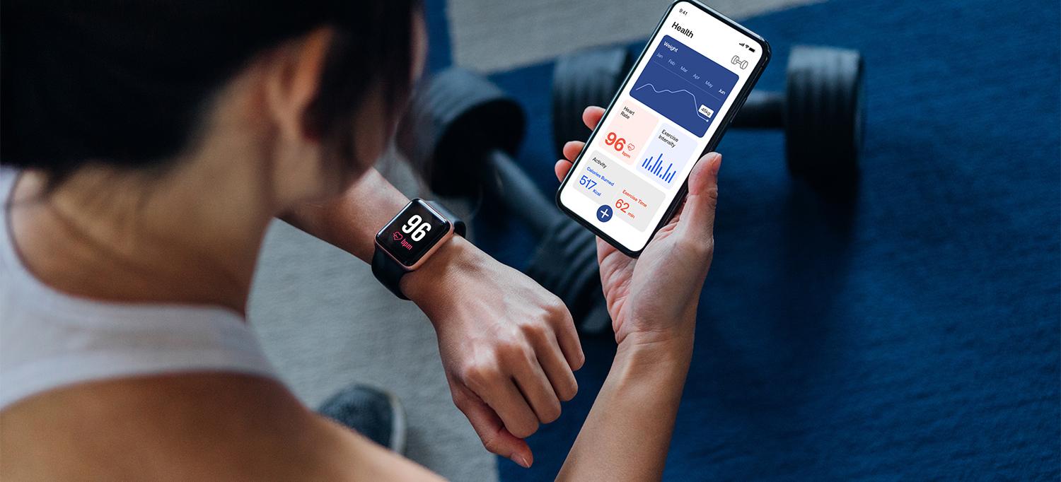 Person Checking Health Stats on Smart Watch and Mobile Phone App