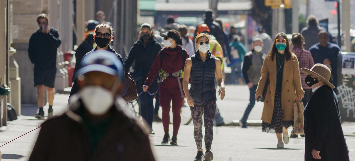 People Wearing Masks Walking on Busy City Sidewalk