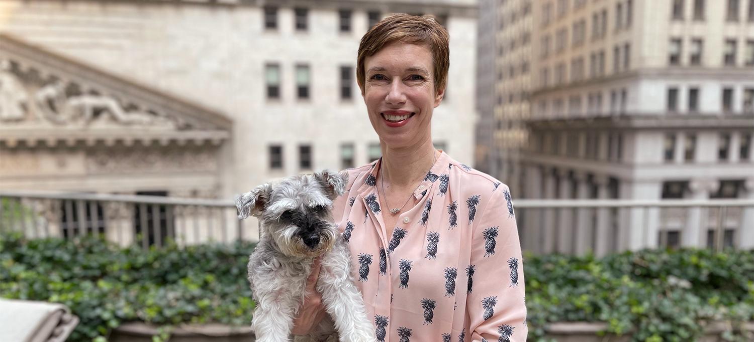 Jane Singleton Smiles While Holding Her Dog on City Rooftop
