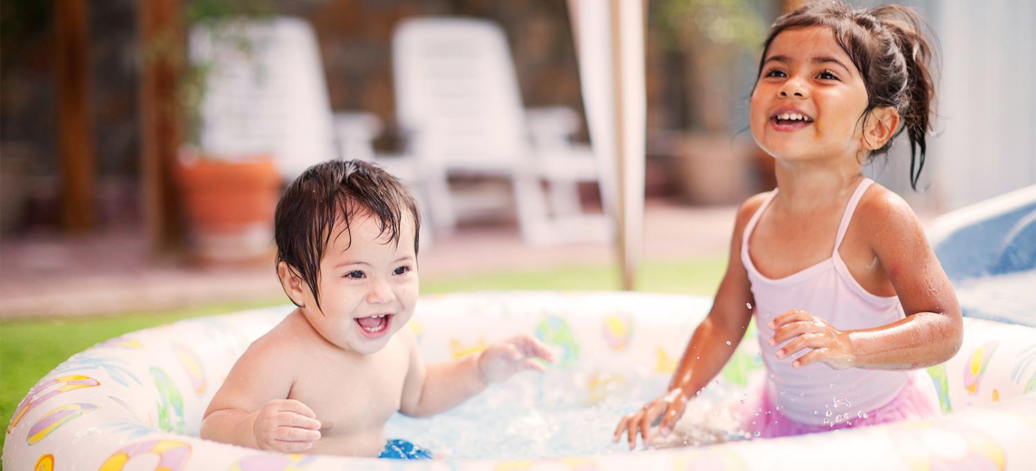 Two Young Children Playing in Inflatable Kiddie Pool