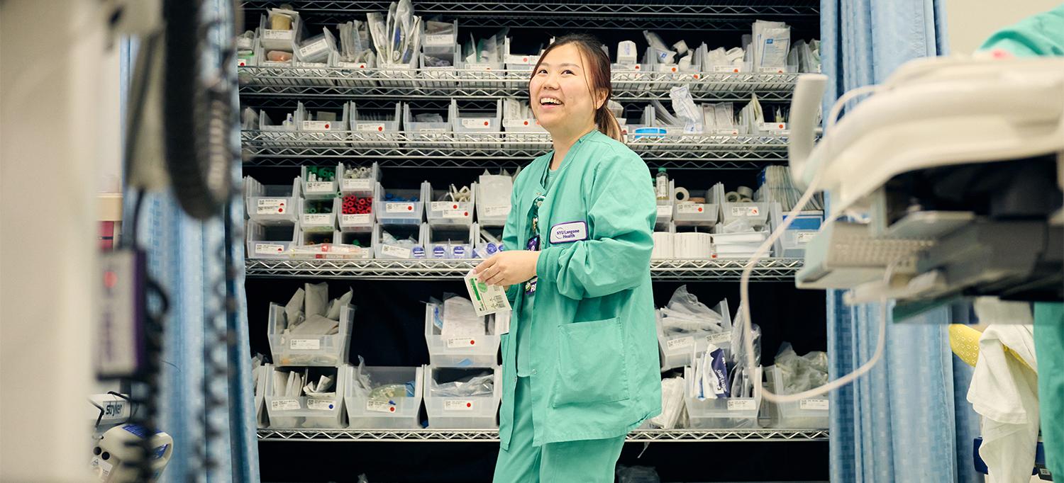 Nurse smiling and grabbing medical supplies from a store room