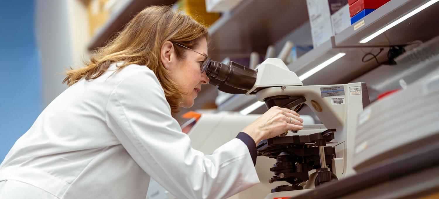 Dr. Moore looks into a microscope.