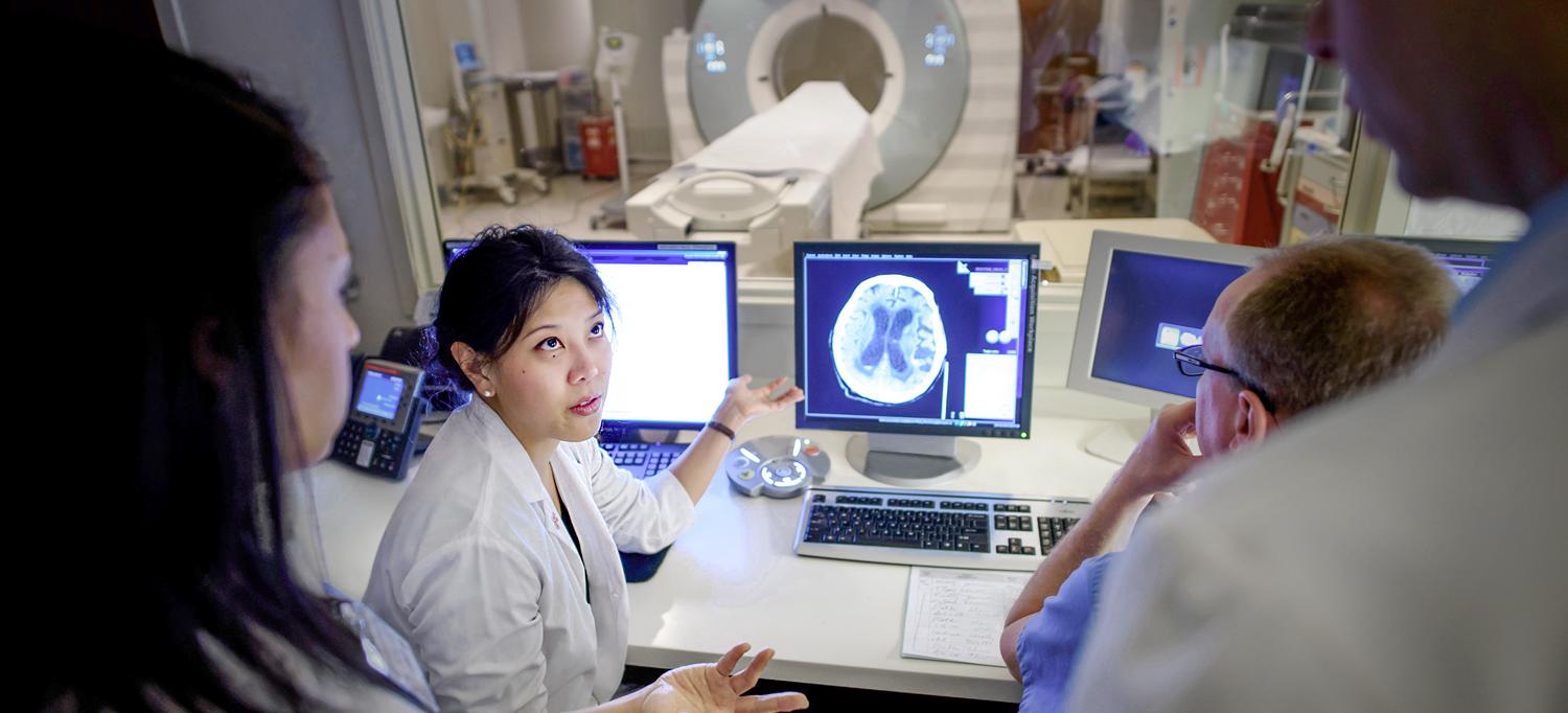 Dr. Koto Ishida looking away from a monitor with a medical image