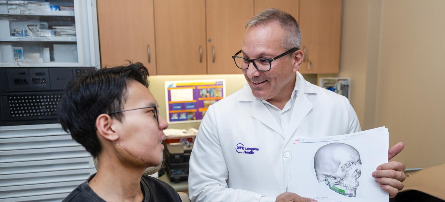 Dr. Adam S. Jacobson speaks with patient about jaw injury.