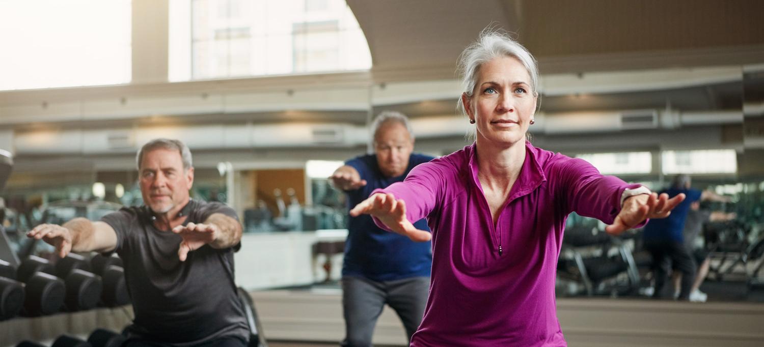 A group of three older adults exercising