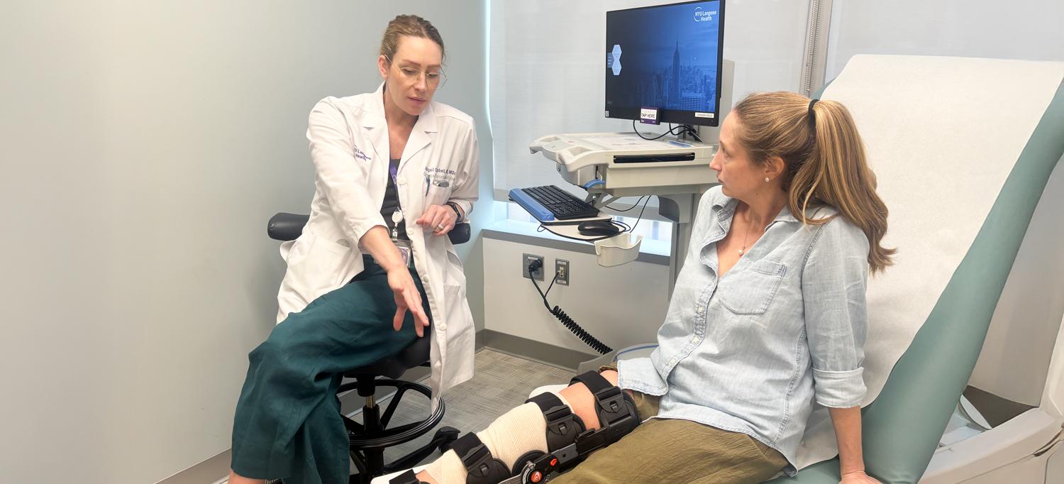 Dr. Campbell speaks to Johnson, who is wearing a brace and sitting on an exam table. Johnson 