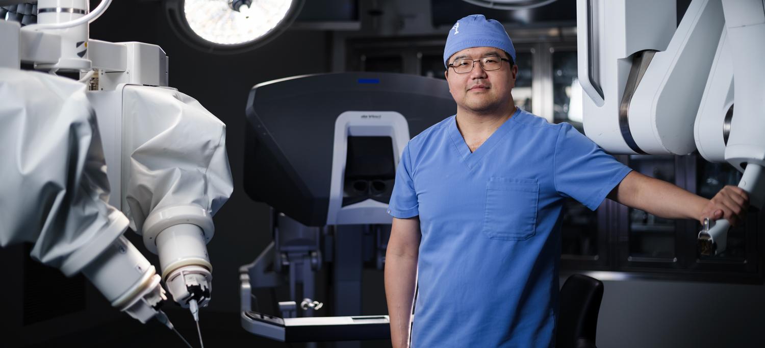 Dr. Lee Zhao stands in scrubs in an operating room.