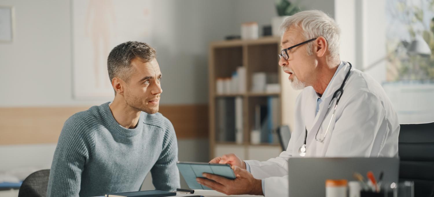 A doctor showing analysis results to a patient during a consultation in a health clinic