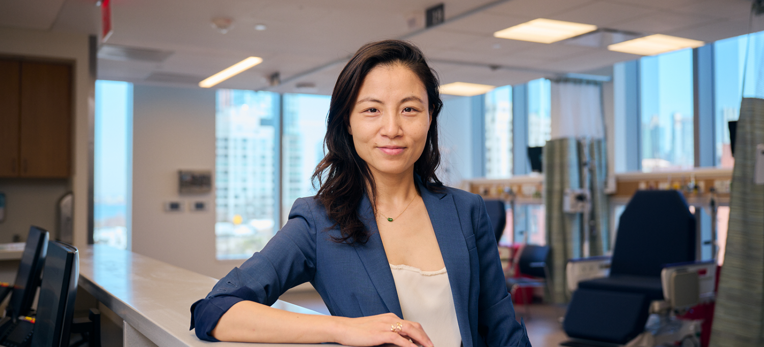 Dr. Kathy Huang pauses at the front desk of a patient care facility. 