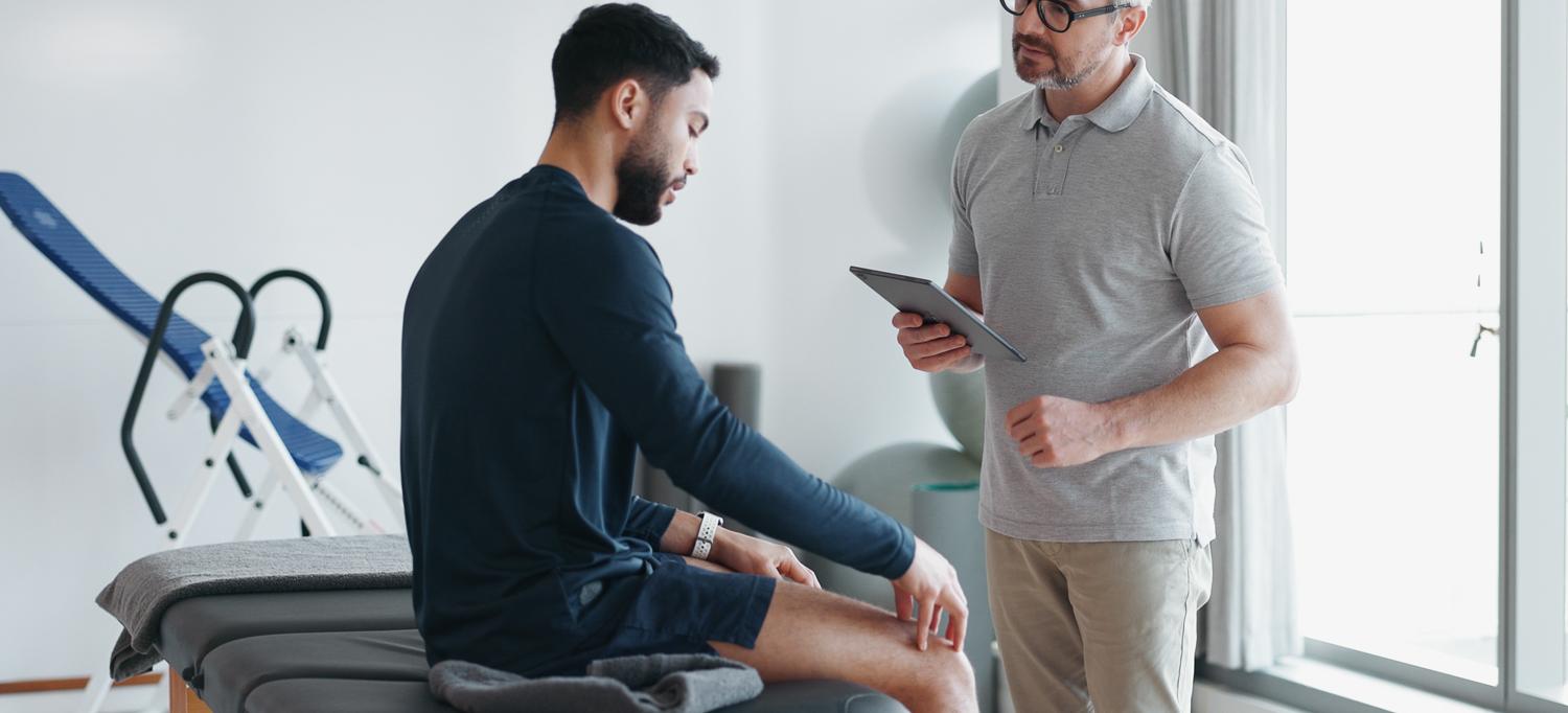 Physical therapist with athlete in the clinic for physical rehabilitation.